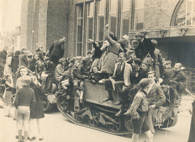 879264 Afbeelding van twee Bren Gun carriers volgeladen met feestvierende burgers waaronder veel kinderen, voor het ...